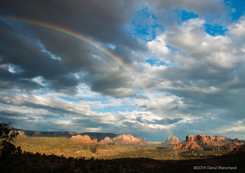 A rainbow arcs across the skies of Sedona and in front of Cathedral Rock.