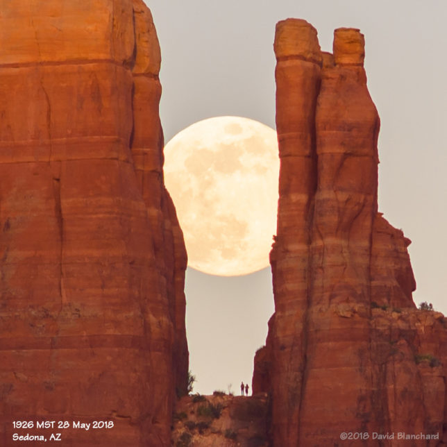 A couple watches the Moon rise from Cathedral Rock.