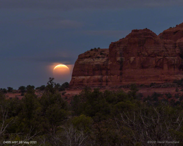 The partially eclipsed Moon is about to set behind Cathedral Rock.