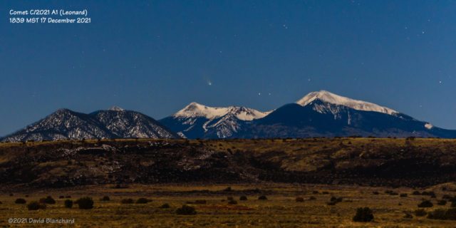A nearly-full Moon illuminates the snow-covered San Francisco Peaks as the comet sets in the evening twilight.