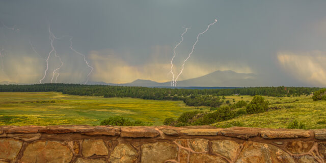 Composite image of multiple lightning strikes with the San Francisco Peaks in the distance.