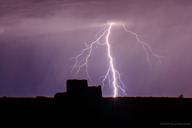 A cloud-to-ground lightning flash creates a silhouette of Wukoki Pueblo in Wupatki National Monument.