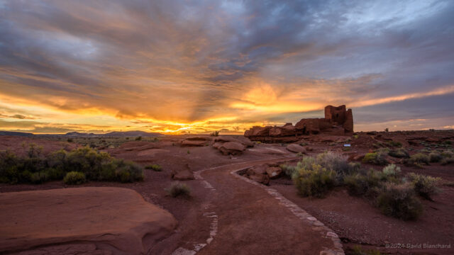 Beams of light from the setting Sun light up the clouds at Wupatki National Monument.