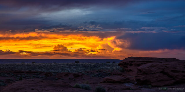 The last light of the setting Sun illuminates a distant storm.