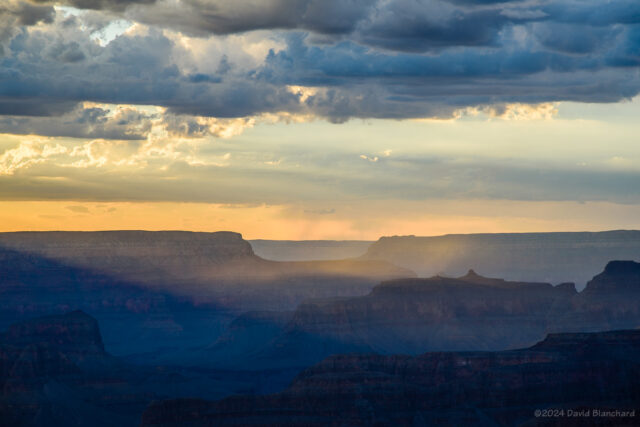 The setting Sun illuminates moisture in Grand Canyon.