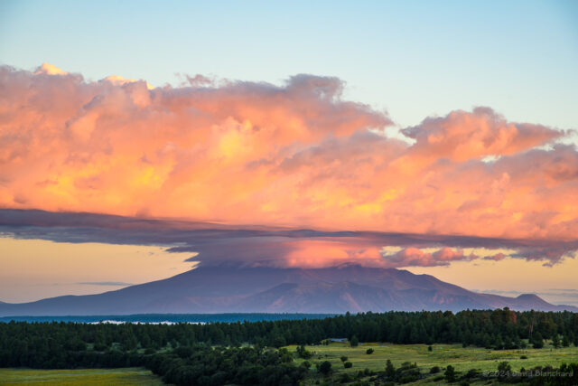 A band of clouds crown the San Francisco Peaks at sunrise.