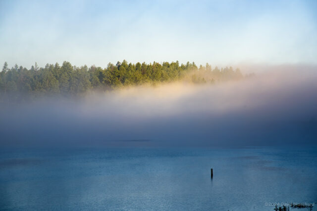 A patch of light and color--likely from a glory--is visible in fog over Upper Lake Mary.